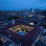 Aerial view of Portrait Milano's historic courtyard complex and surrounding Milan skyline at dusk