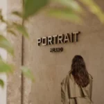 Portrait Milano entrance sign displayed on a textured stone wall beside the hotel doorway