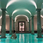Luxury indoor spa swimming pool with turquoise water, arched ceilings and classical columns at Portrait Milano