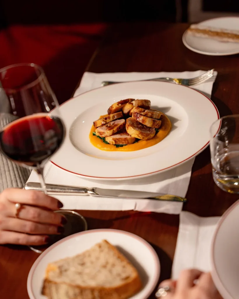 Italian fine dining dish served on a white plate with wine and elegant table settings at Portrait Milano
