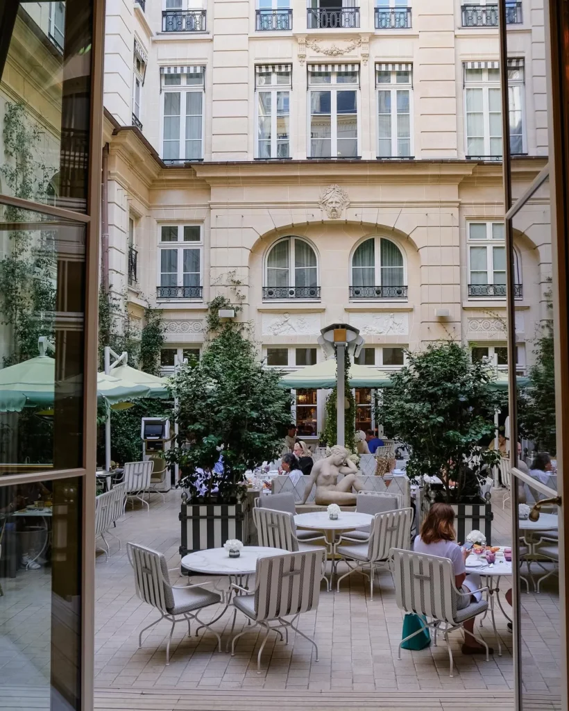 Charming courtyard terrace with outdoor tables and greenery at Rosewood Hôtel de Crillon Paris