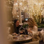 Guests enjoying an intimate dinner beneath decorative lights at Rosewood Hôtel de Crillon Paris