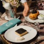 Chef presenting an elegant gourmet dish at Rosewood Hôtel de Crillon Paris