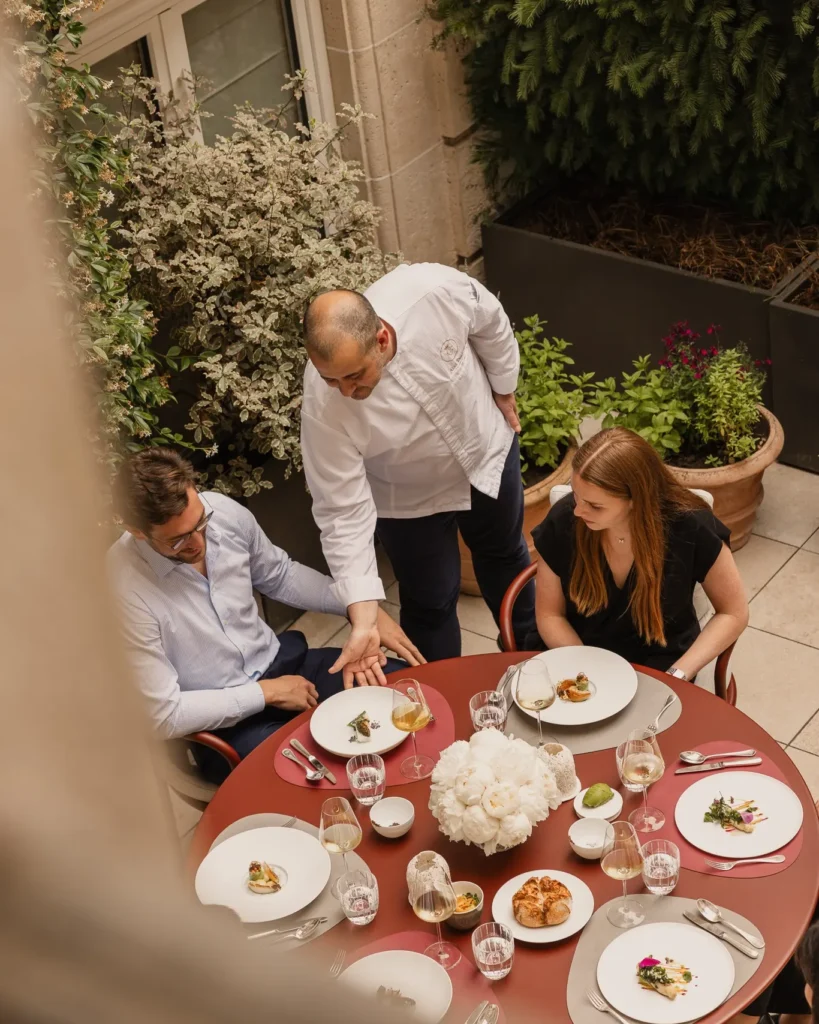 Outdoor dining table set for a meal in the courtyard garden at Rosewood Hôtel de Crillon Paris
