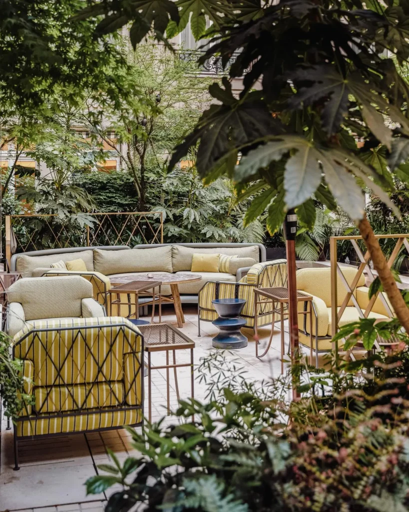 Peaceful garden terrace with cushioned seating and lush greenery at Rosewood Hôtel de Crillon Paris