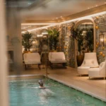 Indoor swimming pool with elegant stone walls and warm ambient lighting at Rosewood Hôtel de Crillon Paris