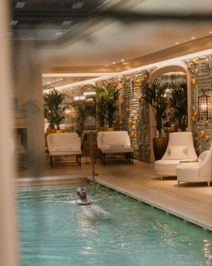 Indoor swimming pool with elegant stone walls and warm ambient lighting at Rosewood Hôtel de Crillon Paris