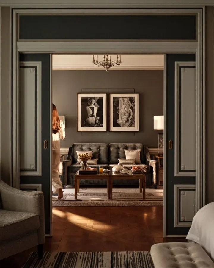 Sophisticated lounge with dark wood furnishings, framed artwork and warm lighting at Rosewood Hôtel de Crillon Paris