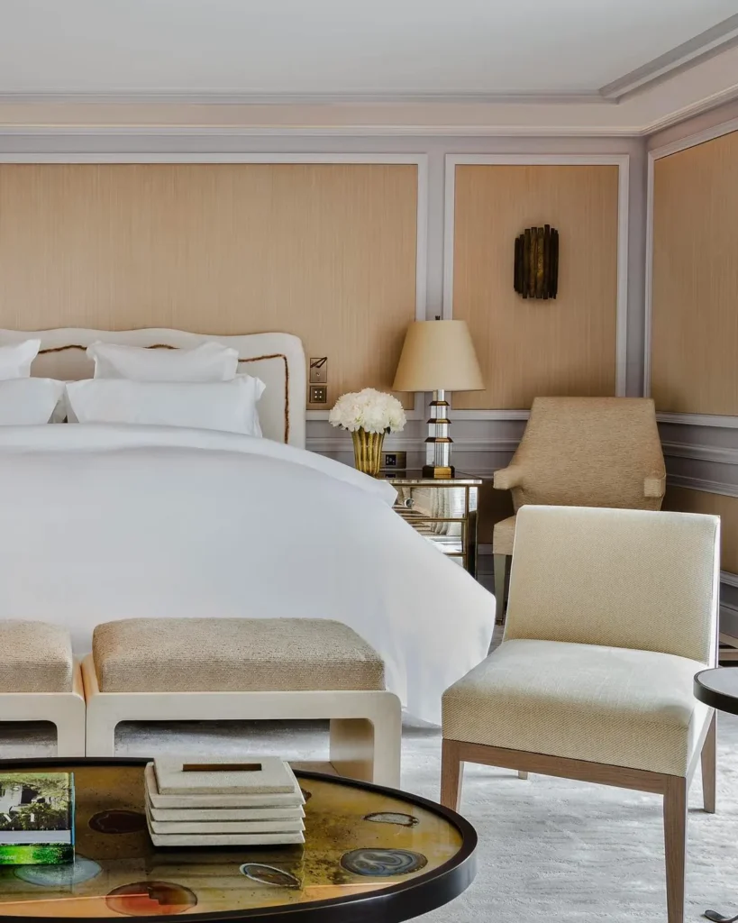 Elegant hotel bedroom with white linens and classic neutral furnishings at Rosewood Hôtel de Crillon Paris