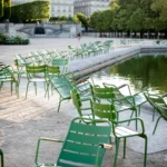 Outdoor terrace furnished with green chairs overlooking a landscaped Parisian setting at Rosewood Hôtel de Crillon