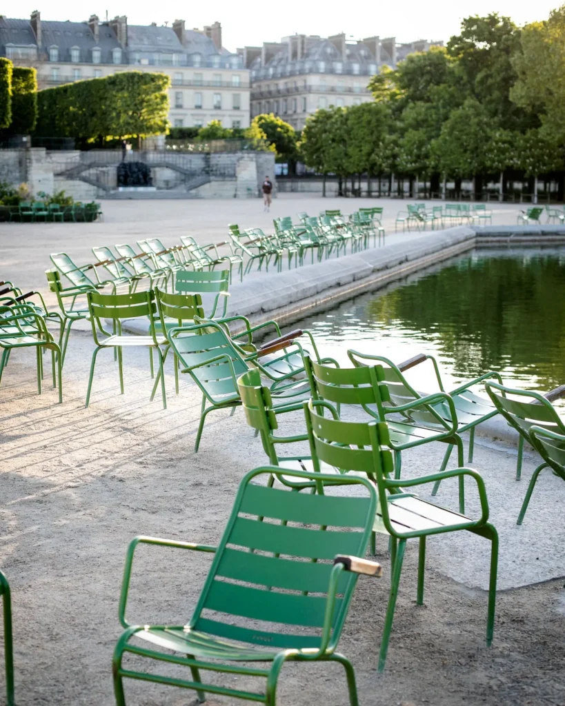 Outdoor terrace furnished with green chairs overlooking a landscaped Parisian setting at Rosewood Hôtel de Crillon