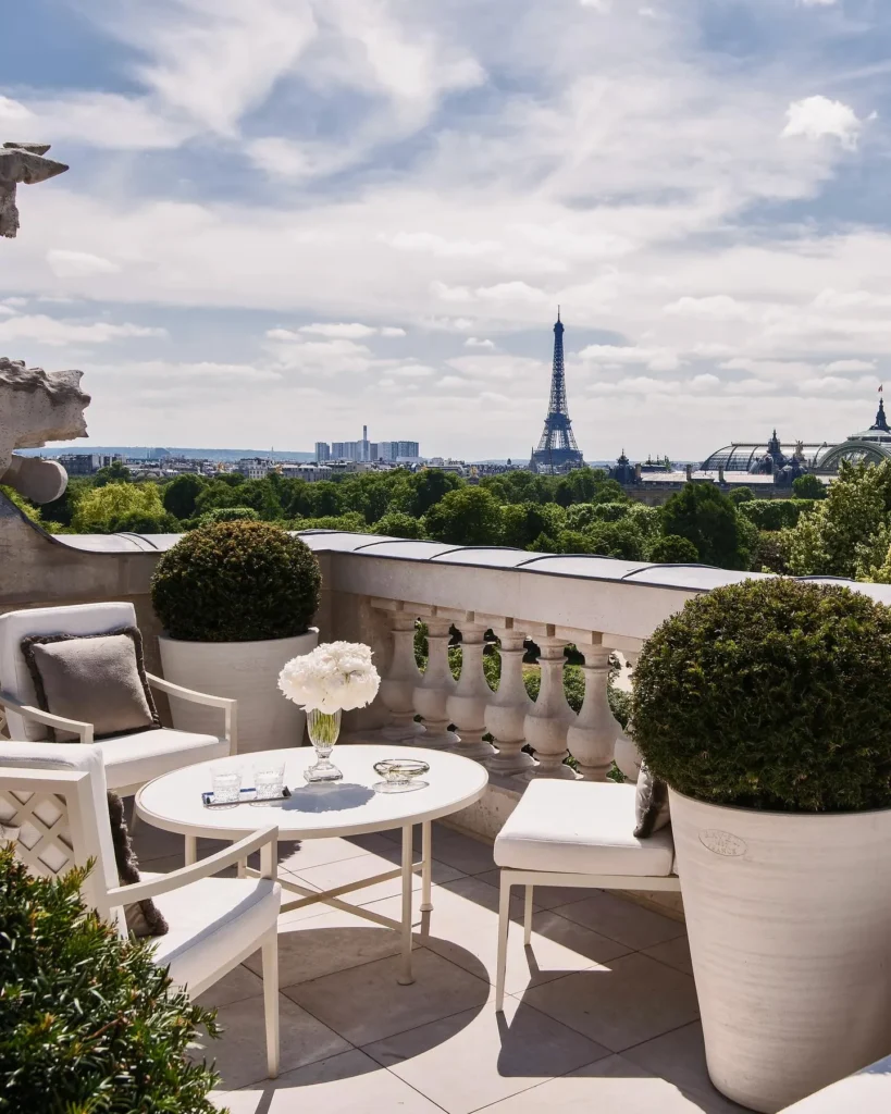 Outdoor terrace with elegant seating and views toward the Paris skyline at Rosewood Hôtel de Crillon