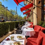 Hôtel Plaza Athénée Paris outdoor terrace dining with red awnings, elegant seating and Eiffel Tower views