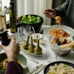 Fine dining experience at The Carlton Milan with beautifully presented dishes, glassware, and elegant table settings beside a window