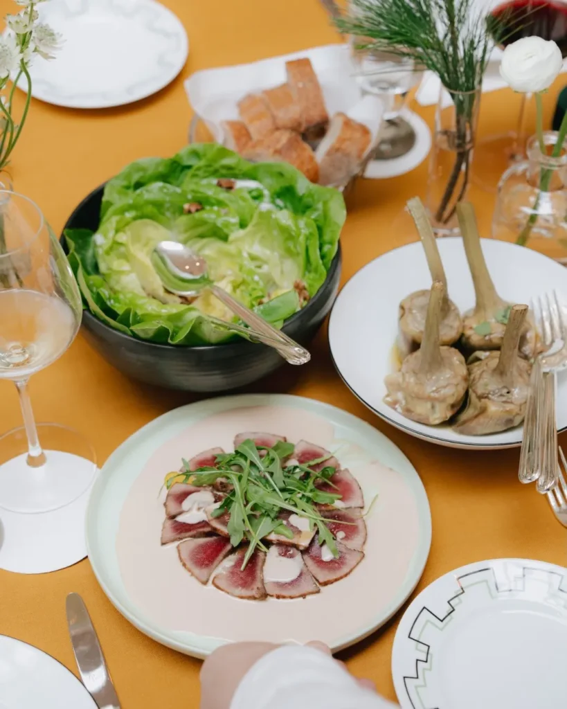 Overhead view of a gourmet meal at The Carlton Milan featuring several colorful dishes arranged across a dining table