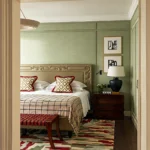 Luxury bedroom at The Carlton Milan framed by a geometric doorway, with a patterned bedspread and refined contemporary decor