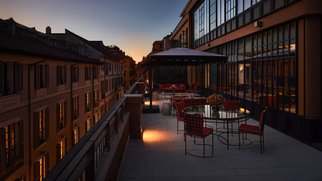 Outdoor terrace of The Carlton Milan Presidential Suite featuring elegant seating, warm architectural lighting, and views across surrounding rooftops