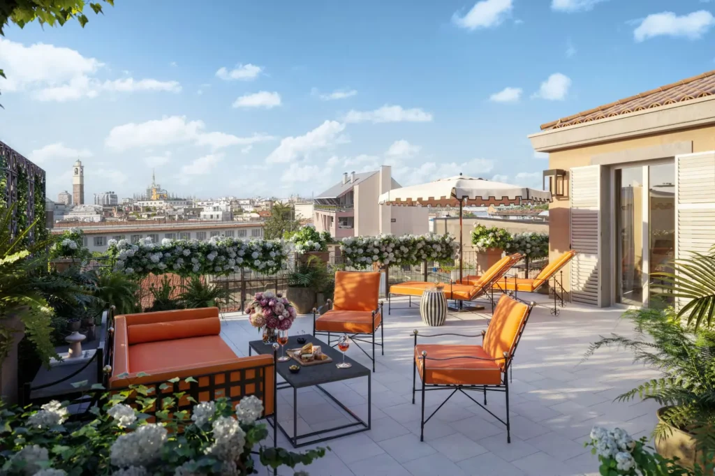 Scala Suite terrace at The Carlton Milan with colorful lounge chairs, landscaped planters, and views over Milan rooftops